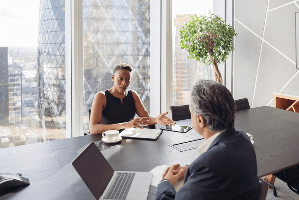 A man and a woman are sitting at a conference table